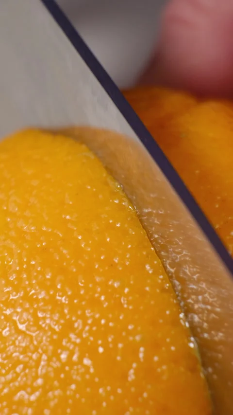 Close up of a knife slicing an orange Stock Footage 301523095