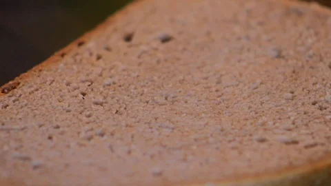 Close-up of a knife spreading butter on a slice of bread Stock Footage 87857407