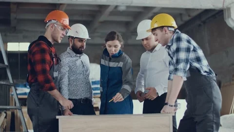 A close-knit team of builders at a construction site. Discussion of the plan Stock Footage 130776813