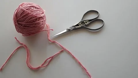 A close-up of a knitting project in progress, featuring pink knitting Stock Footage 285055956