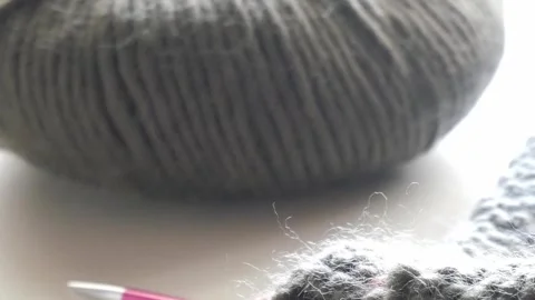 A close-up of a knitting project in progress, featuring pink knitting Stock Footage 285056004