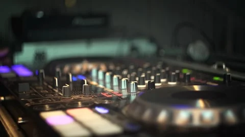 Close-up of knobs and controls on a DJ sound mixer, colorful disco lights Video stock 319613513