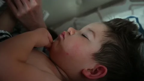 Close up of l little boy does not want to wake up, the mother wakes up her son Stock Footage 170481381