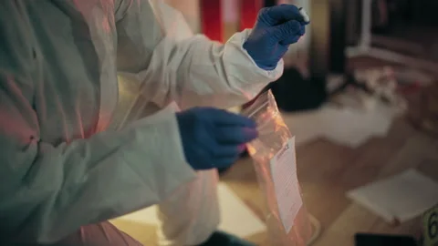Close-up of lab analyst collecting evidence in bag, working at crime scene Stock Footage 189449501