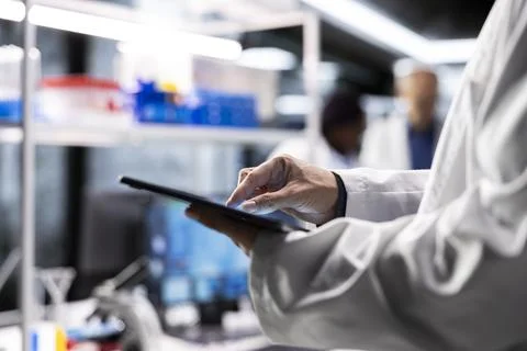 Close up of lab expert at work reviews chemical data on tablet Stock Photos