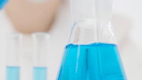 Close-up of a lab worker quickly stirring with a glass dropper Stock Footage 128234210