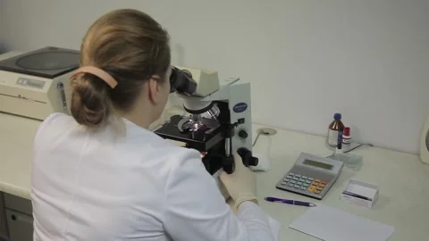 Close-up. laboratory assistant  sits in a laboratory near a powerful microscope. Stock-Footage 132251591