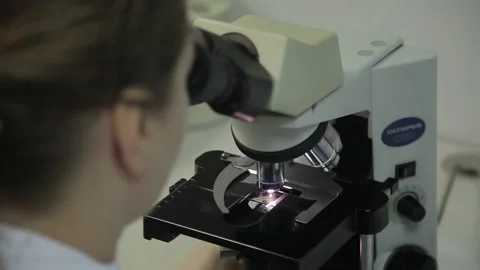 Close-up. laboratory assistant  sits in a laboratory near a powerful microscope. Stock Footage 132251636
