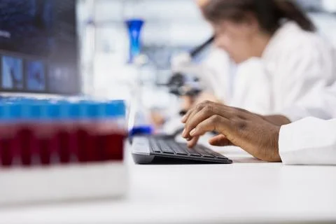 Close up of laboratory researcher using computer software to process DNA data Foto stock