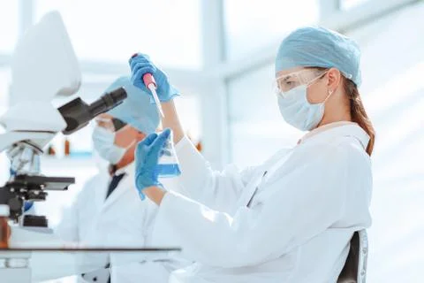 Close up. laboratory technician testing liquid in a laboratory flask . Stock Photos