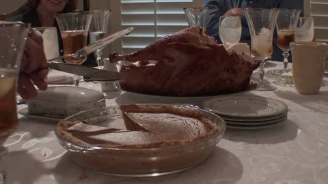 Close of laden Thanksgiving table as pumpkin pie is cut, 4K. Stock Footage 81645998