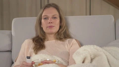 CLOSE UP: Lady enjoying on a comfy sofa and watching entertainment TV program Stock Footage 219366507