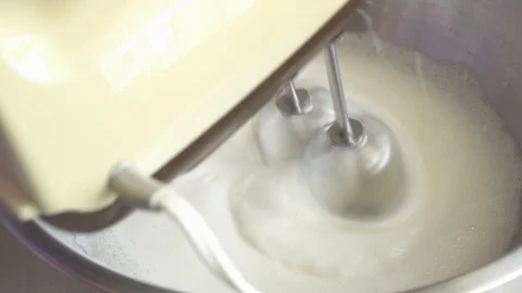 Close up of A lady Hands Mixing White Egg Cream In Bowl Using Motor Mixer Stock Footage 109405909