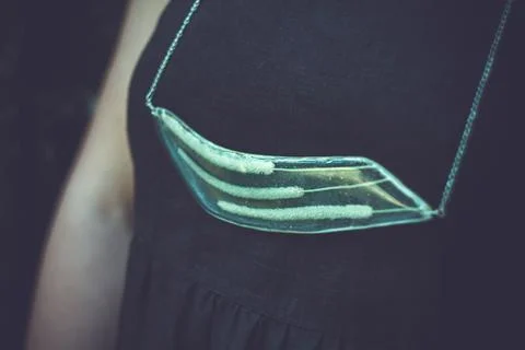 Close up lady presenting transparent pendant with dry spikelets concept photo Stock Photos