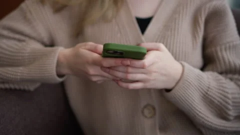 Close-up of lady using iphone with green case in casual setting Stock Footage 304974618