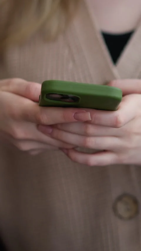Close-up of lady using iphone with green case in casual setting Stock Footage 318209628