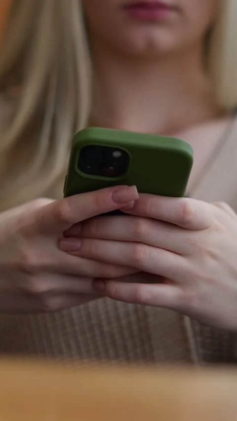 Close-up of lady using iphone with green case in casual setting Stock Footage 318224414