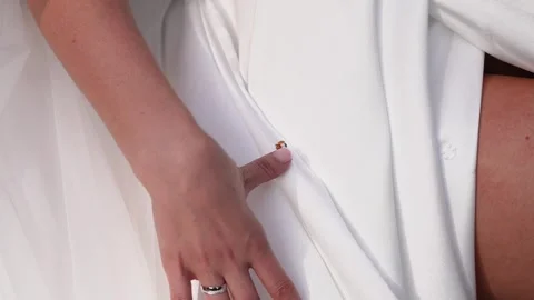 Close-up of Ladybug Crawling on Bride's White Wedding Dress Outdoors Video stock 343845398
