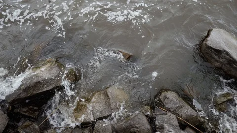 Close up lake waves over coast rocks, slow motion, 60 fps Video stock 129636585