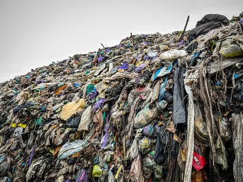 Close-up landfill garbage wall compacted plastic waste environmental Stock Photos