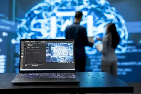 Close up of laptop with AI powered script code running next to engineers Foto stock