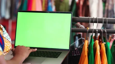 Close-up of laptop computer with a green screen in a clothing boutique Stock Footage 346563852