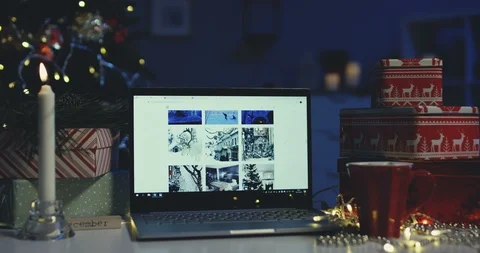 Close up of the laptop computer with winter pictures on its screen on the table Stock-Footage 99796359