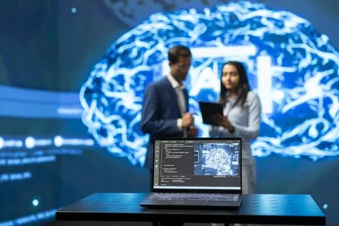 Close up of laptop displaying AI model source code in front of engineers Stock Photos