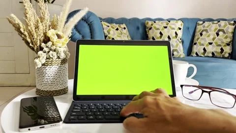 Close-up of a laptop with a green screen, glasses, and a cup of coffee Stock Footage 338364903