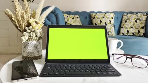 Close-up of a laptop with a green screen, glasses, and a cup of coffee 库存影片 338364959