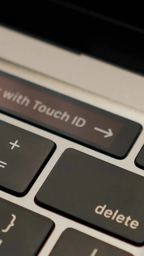 Close up of laptop keyboard with Unlock with Touch ID sensor. Vertical video Stock Footage 293778041