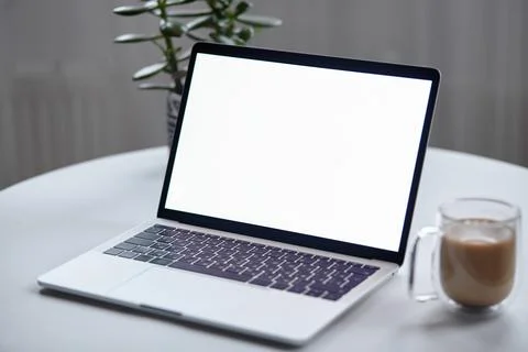 Close up laptop screen mockup on table with coffee cup and houseplant at home Stock Photos
