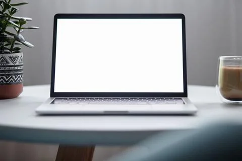 Close up laptop screen mockup on table with coffee cup and houseplant at home Foto stock