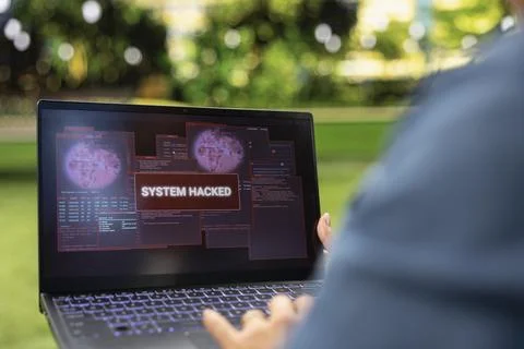 Close up of laptop showing red system hacked warning and digital threat Stock Photos
