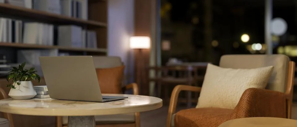 Close-up of a laptop on a table, surrounded by cozy armchairs in a contempo.. Stock Illustration