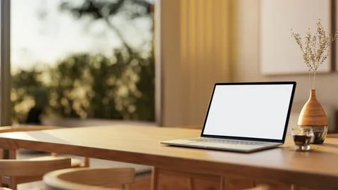 A close-up of a laptop with a white screen mockup on a hardwood dining tabl.. Stock Illustration