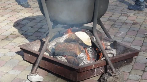 Close up of large cauldron with food on the fire in the middle of street. Stock Footage 106610865