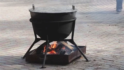 Close up of large cauldron with food on the fire in the middle of street. Stock Footage 106610880