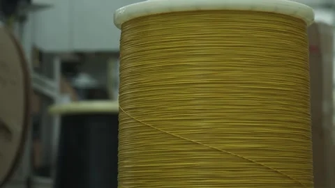 Close-up of a large coil of cable being fed into a cable cutting machine Stock Footage 321896833