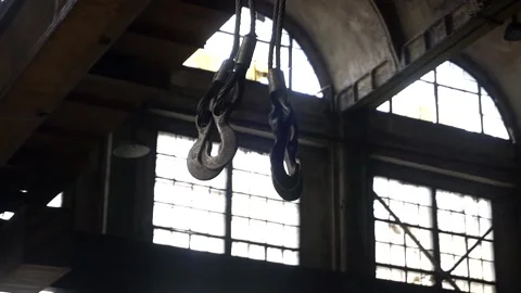 Close-up large crane hooks hang in a large industrial hangar. Stock Footage 145711259