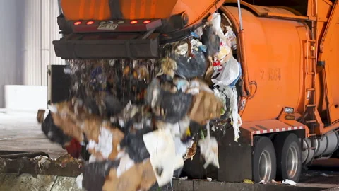 Close-up large garbage truck offloading refuse at a waste transfer station. Stock Footage 272344957
