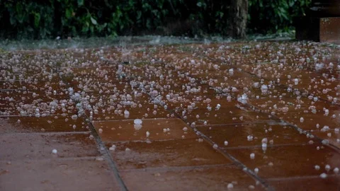 Close up of large hail stones falling on outdoor tile during a storm Stock Footage 102715153