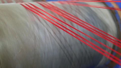 Close-up large industrial spool rapidly winding machine wind a red thread in Stock Footage 318063816