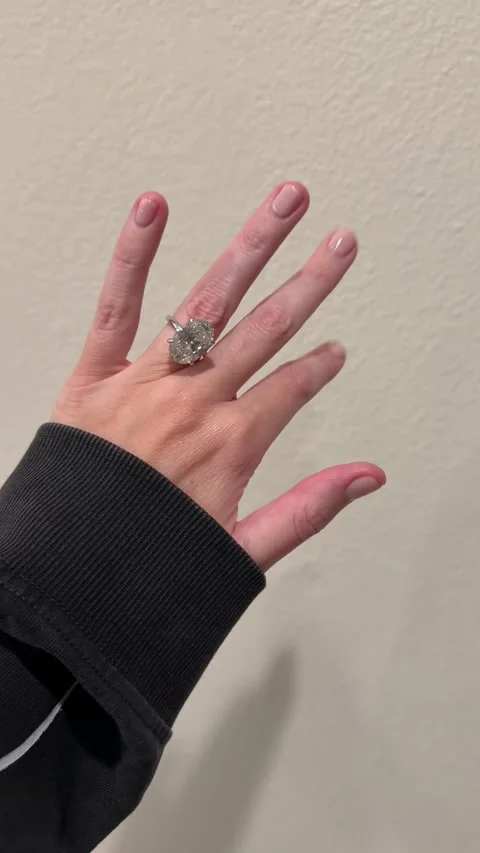 Close up large oval diamond solitaire engagement ring on hand minimal background Stock Footage 325876931