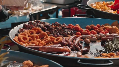 Close-up of a large pan filled with grilled sausages, chicken, onion rings Stock Footage 345499570