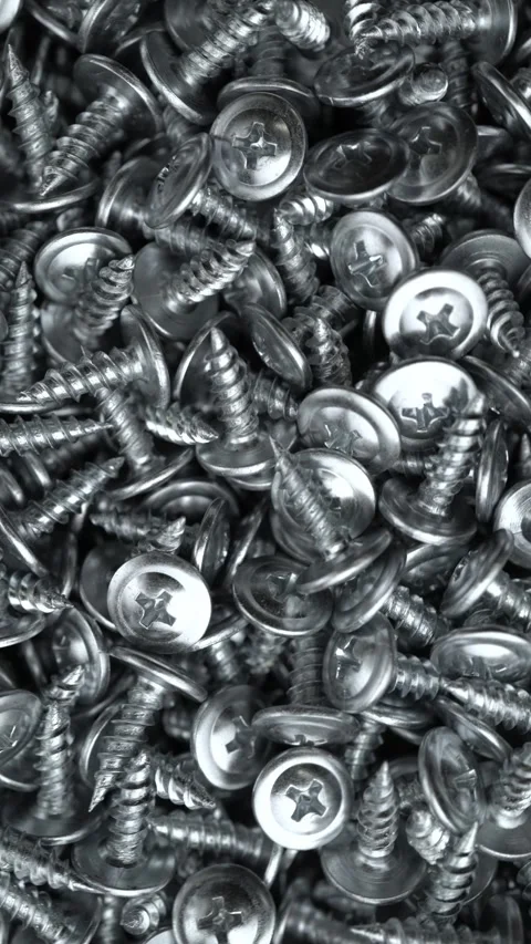Close-up of a large pile of shiny silver metal screws. Ideal for industrial Stock Footage 342299927