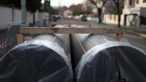 Close-up of large plastic pipes wrapped in protective film, placed on a resident Stock Footage 304885324