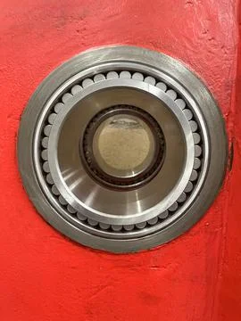 Close up of a large roller bearing inserted in a red machine frame Stock Photos