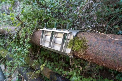 Close-up of a large rusty water pipe repaired with a metal clamp and bolts. Fotos Stock