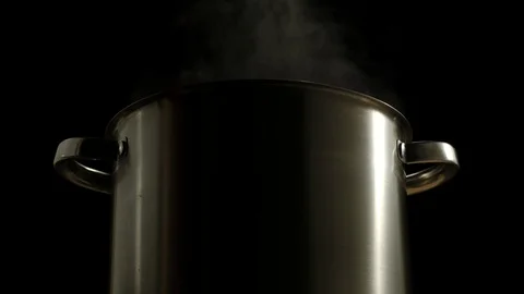CLOSE UP: Large Saucepan Boiling With Steam On A Black Background Stock Footage 117649008